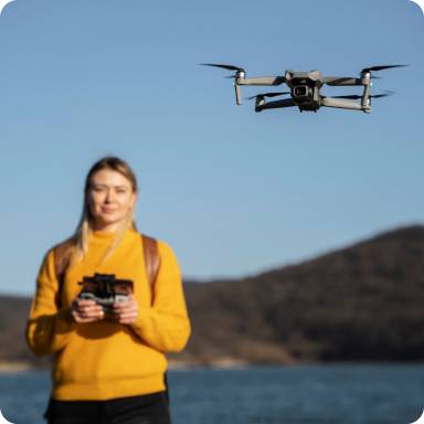 Une femme passe une formation drone à Lyon. Un drone vol devant elle. Formation Drone à Lyon